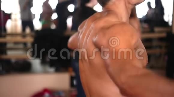 一躯干的男性健美运动员用阻力带做运动的侧视视频的预览图
