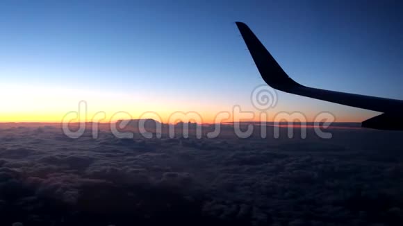 从飞机窗户看到的云彩和天空在城市上空的夜晚视频的预览图