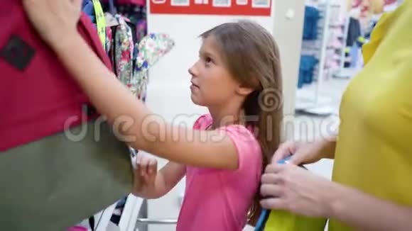 在哈伯达舍市场白人母女在商店货架旁选择书包背包视频的预览图