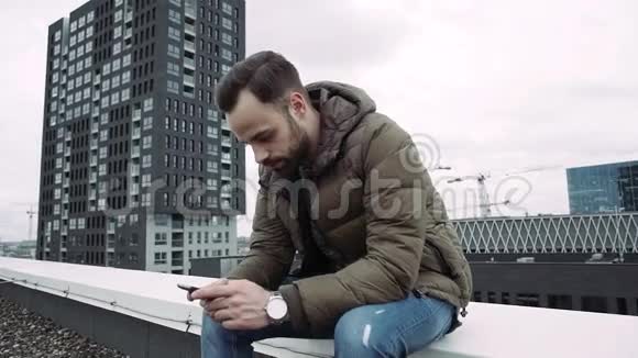 小男孩站在屋顶上手里拿着手机写着留言慢动作视频的预览图