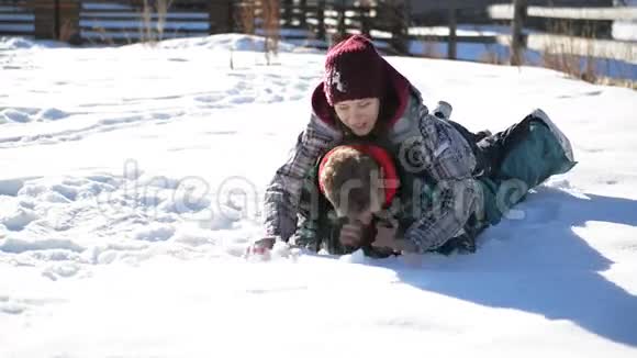 幸福的夫妇躺在雪地上在山区的寒假里享受温暖的阳光日有趣搞笑视频的预览图