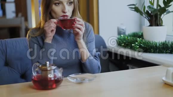 美丽的女人在梦中微笑着在咖啡馆的窗口喝茶视频的预览图