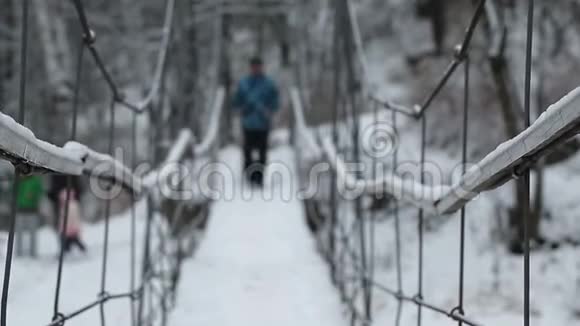冬天挪威人沿着悬索桥在河上散步视频的预览图