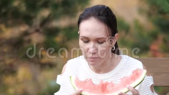 女孩在公园里吃西瓜慢动作视频生活方式女孩和西瓜的概念视频的预览图