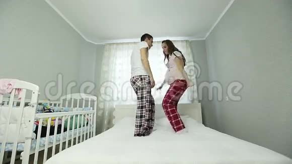 一个孕妇和一个穿睡衣的男人在床上跳舞视频的预览图