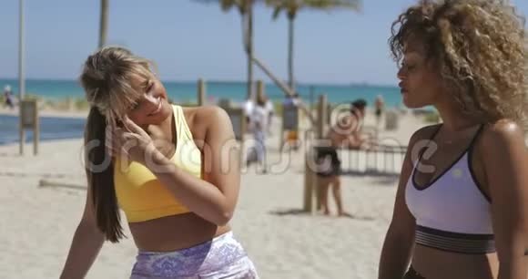 在热带海岸聊天的女运动员视频的预览图