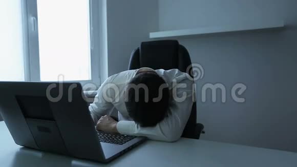 年轻英俊的男人躺在桌子上睡觉视频的预览图