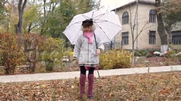 女孩子在公园里的伞下行走视频的预览图