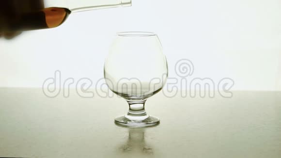 在玻璃中人从白色背景的瓶子里倒出酒精视频的预览图