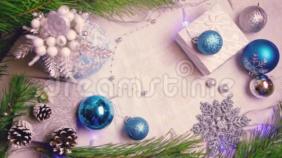 女人手把一份圣诞礼物放在装饰好的桌子上上面有闪烁的灯光和圆锥形的俯视图视频的预览图