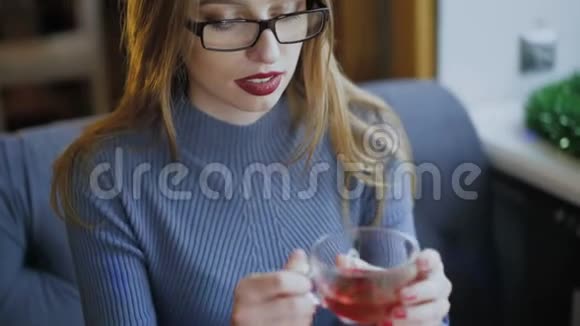 美女喝热茶对着镜头微笑的画像视频的预览图