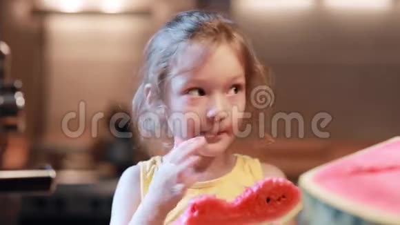 厨房里拿着一块西瓜的可爱小女孩的肖像女性舔水果和咬肉视频的预览图