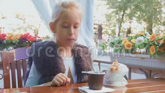 可爱的少女坐在咖啡馆里微笑放松喝茶视频的预览图
