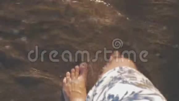 度假者沿着海边散步海浪拍打他的脚视频的预览图