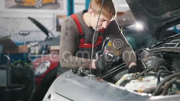 机械师检查和修理汽车发动机汽车修理在车间工作大修视频的预览图