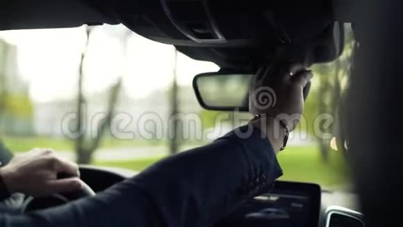 商人开着车看着后视镜库存坐在车里的商人从后面看视频的预览图