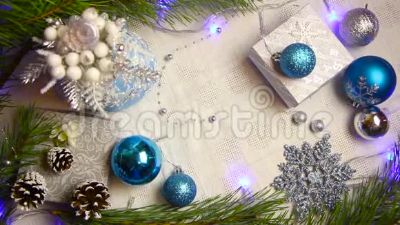 女人手把一份圣诞礼物放在装饰好的桌子上上面有闪烁的灯光和圆锥形的俯视图视频的预览图