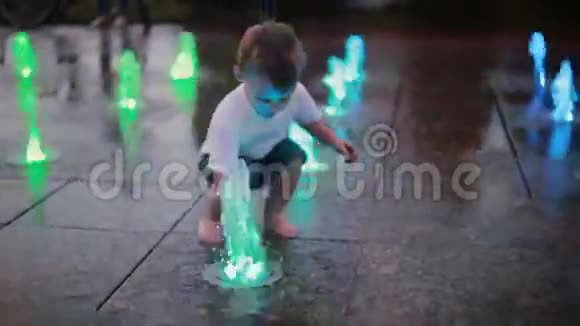 有魅力的小男孩跑水槽喷泉和触摸喷水孩子们在炎热的夏天玩得很开心视频的预览图