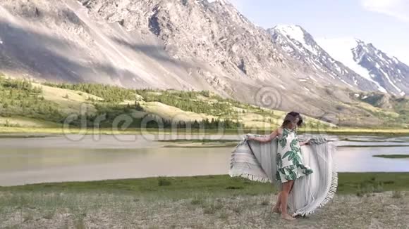 一个年轻的女人穿着裙子在群山的背景下跳舞和跑步视频的预览图