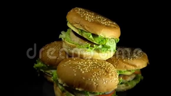 四个开胃的汉堡围绕着一个黑色的背景视频的预览图