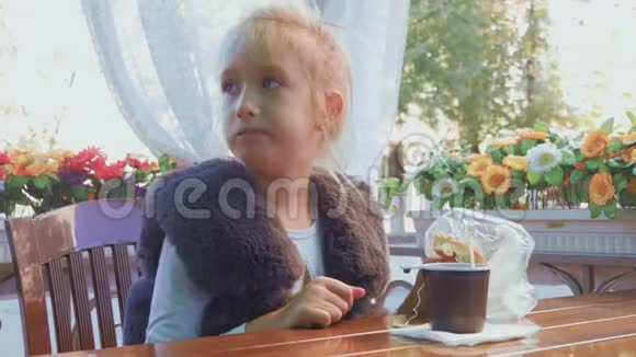 可爱的少女坐在咖啡馆里微笑放松喝茶视频的预览图