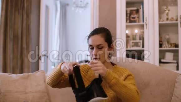 年轻的女人戴着VR头套在家里环顾四周拿起虚拟现实的眼镜视频的预览图