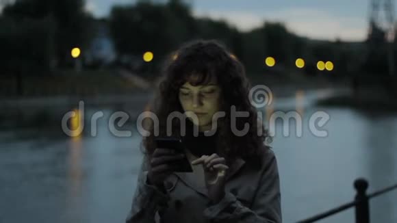 孤独的年轻女人用她的智能手机视频的预览图