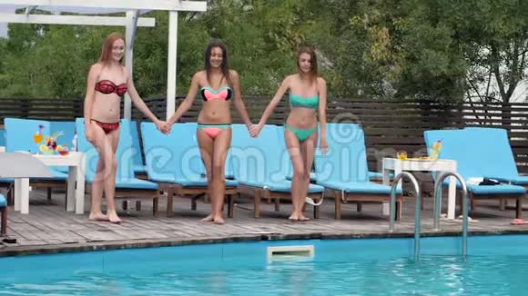 穿着泳装的女伴们跳进游泳池水上聚会穿着泳衣的漂亮女朋友潜入水中视频的预览图