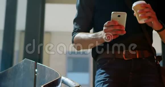 男性通勤者在喝咖啡时使用手机视频的预览图