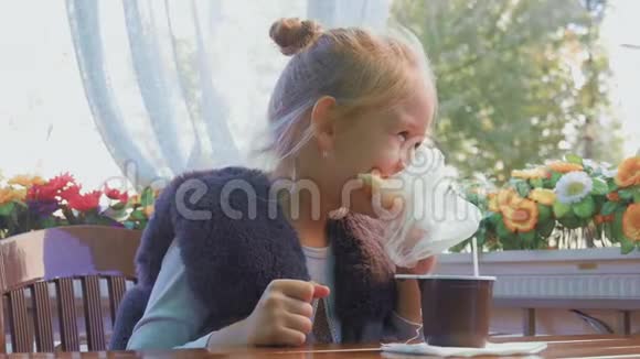 可爱的少女坐在咖啡馆里微笑放松喝茶视频的预览图