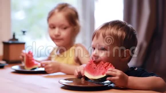 两个可爱的孩子女孩和男孩在吃西瓜兄妹俩坐在餐桌前一起吃了一顿饭视频的预览图