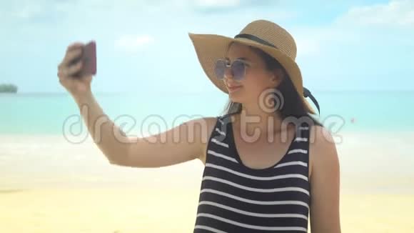 美丽的年轻女人在海滩上自拍视频的预览图