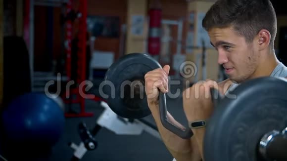 一个运动健美的年轻人在健身房锻炼二头肌视频的预览图