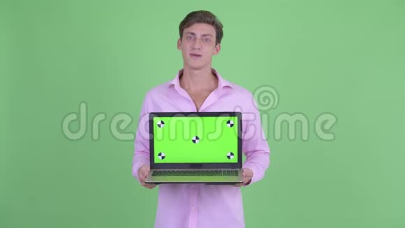 快乐的年轻英俊的商人说话展示笔记本电脑视频的预览图