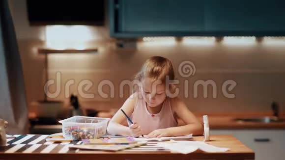 小女孩坐在桌子旁用彩色笔在大房间里画光线柔和摸鼻子视频的预览图