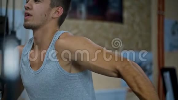 这个人在阻滞装置上训练二头肌和手臂肌肉视频的预览图