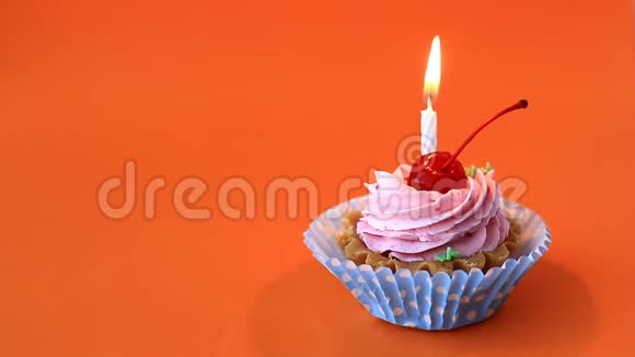 生日蛋糕与樱桃粉红色奶油和燃烧蜡烛为生日在橙色背景延时录像视频的预览图