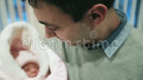 一位幸福的父亲抱着一个新生婴儿在他怀里的特写镜头视频的预览图