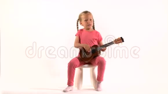 穿着紫色裙子的小女孩在弹着四弦琴唱歌视频的预览图