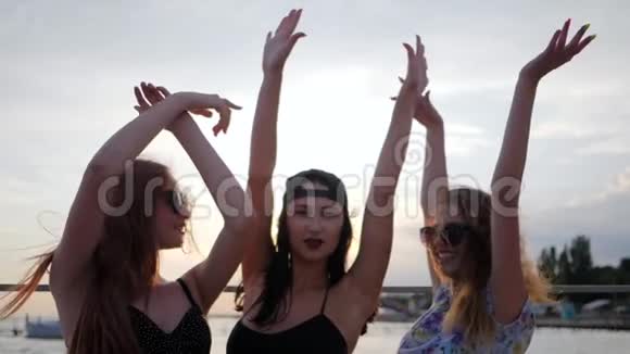 快乐最好的女朋友在日落时在海滩上跳舞三个女人在海边举起手臂夏天的晚上视频的预览图