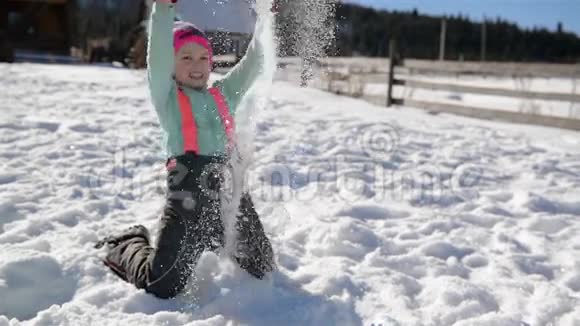 长得漂亮的小女孩在山上的乡村度假期间在雪地里玩耍可爱的孩子视频的预览图