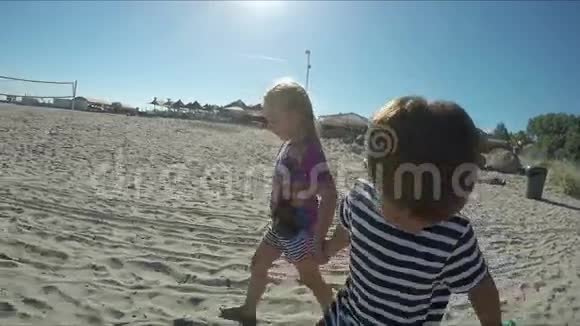 美丽的女孩和男孩赤脚在沙滩上视频的预览图