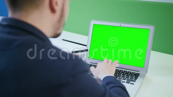 一个年轻人用带有绿色屏幕的笔记本电脑视频的预览图