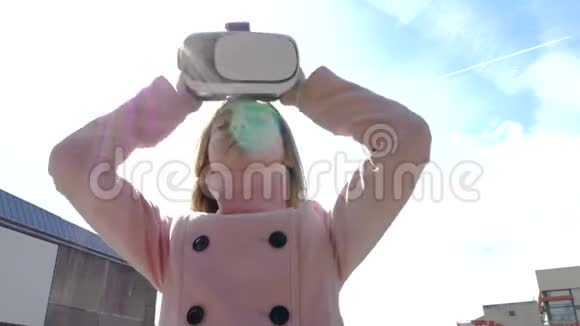 一个女孩在明亮的阳光下戴上虚拟现实的头饰视频的预览图