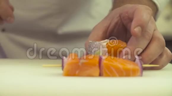 厨师用手在鱼上浇酱汁和盐视频的预览图