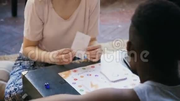 多种族夫妇一起玩棋盘游戏男人和女人把任务做成卡片一起笑视频的预览图