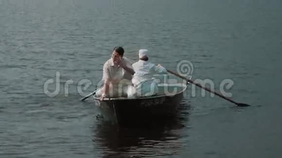 护士在湖上划艇穿着白色衣服的在做鬼脸开玩笑视频的预览图