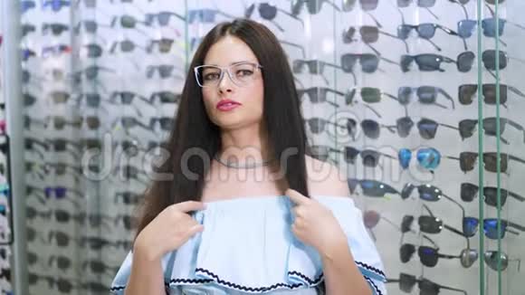 美丽的女人盯着相机一家光学商店里戴眼镜的微笑女顾客的画像视频的预览图