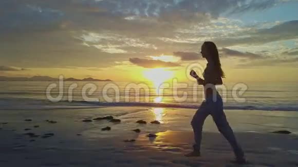 Flycam秀节目女孩在沙滩上迎着朝阳奔跑视频的预览图