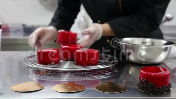 一个糖果师用巧克力片装饰新鲜制作的单份蛋糕然后放在金色蛋糕板上视频的预览图